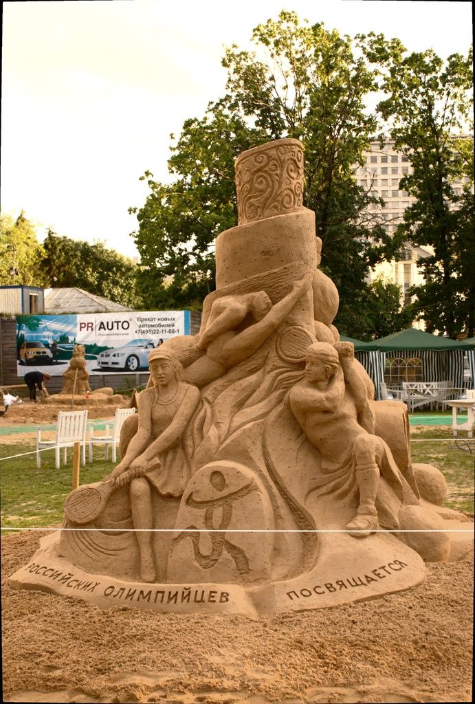 In this image in the middle we can see sand art and around it there is a fence. In the background...